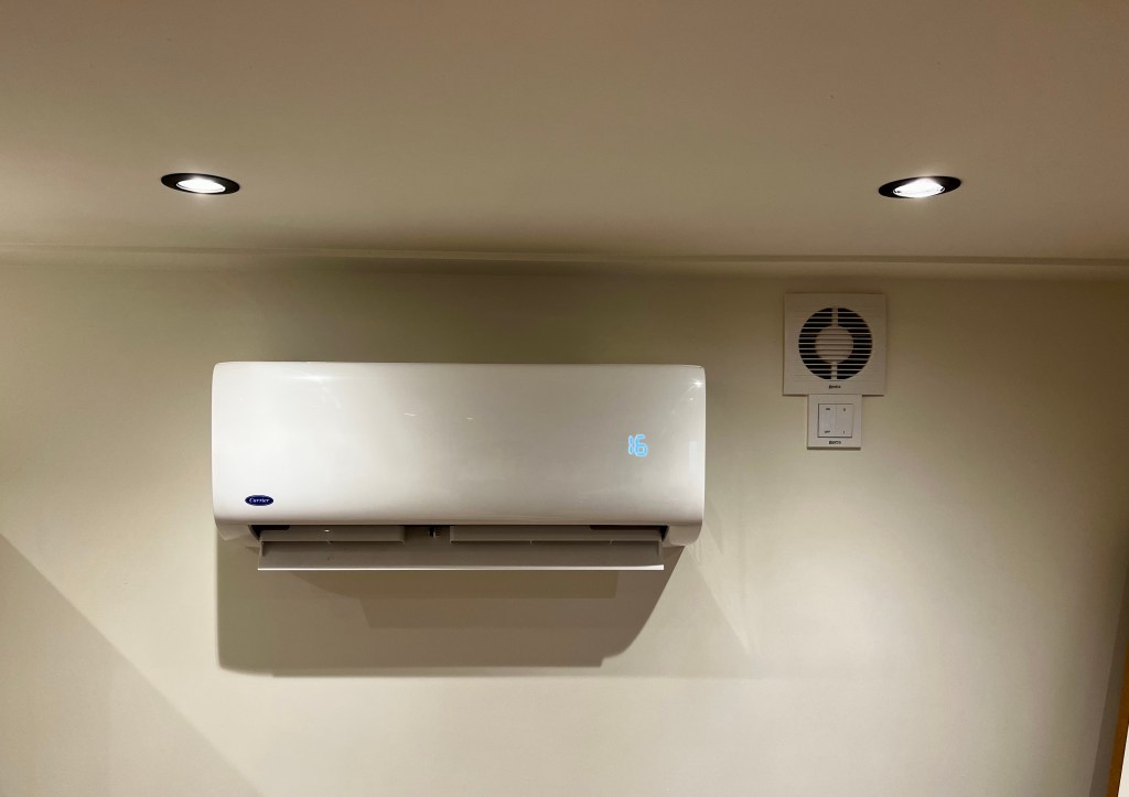 Binnenunit van een Carrier airconditioner gemonteerd aan de muur in een kamer, met een wit, strak ontwerp.
