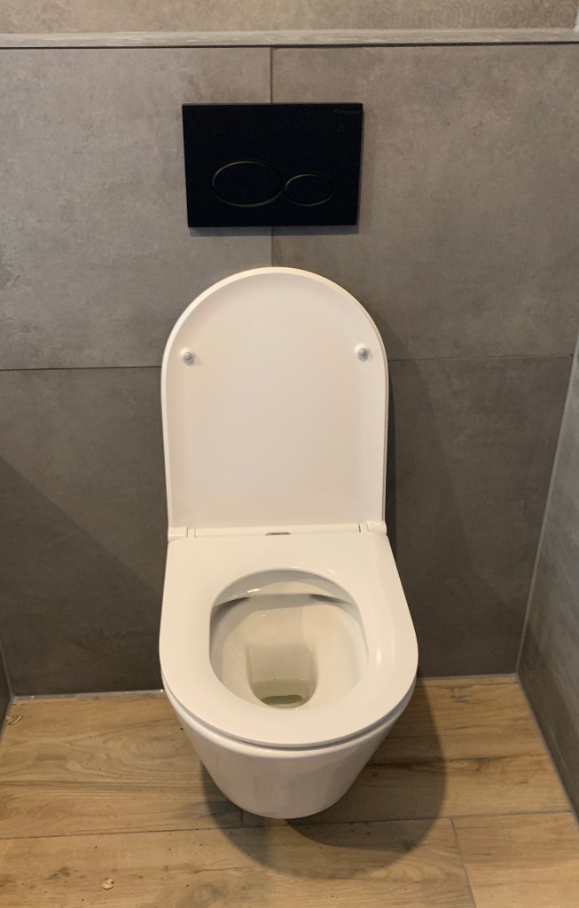 Modern hangtoilet met strak design, geïnstalleerd tijdens een recente toiletrenovatie.