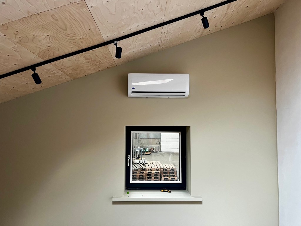 Carrier High Wall wandunit binnenunit, gemonteerd aan de muur in een kamer.