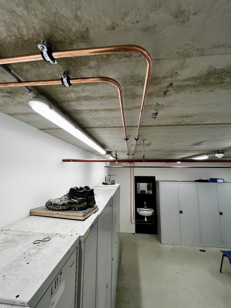 Sanitairinstallatie in een bedrijfspand, met aangelegde waterleiding, wasbak, fontein, kraan, spiegel, afvoer/ riolering