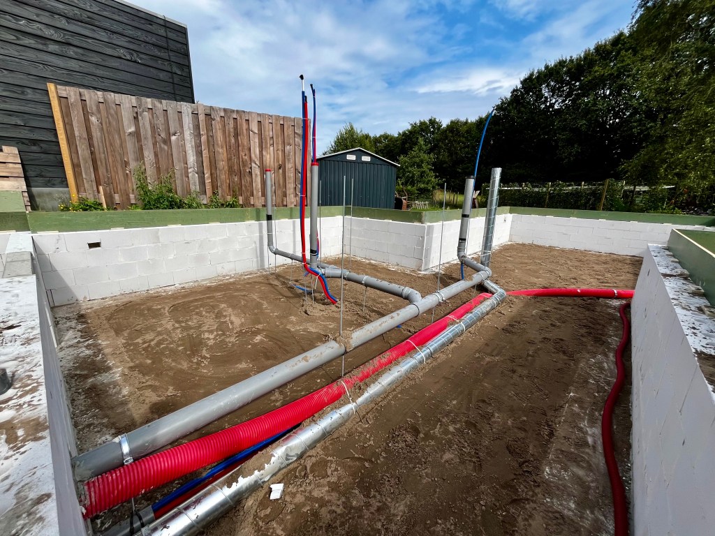 Loodgieterswerkzaamheden uitgevoerd, zichtbaar in de ruwbouw van de aanbouw: riolering, afvoer, waterleiding, verwarmingsleiding, mantelbuis en ventilatie. 