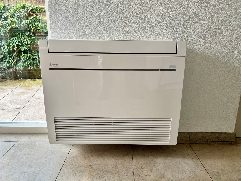 Mitsubishi Electric vloermodel binnenunit, geplaatst voor efficiënte luchtverwarming en koeling in een ruimte.