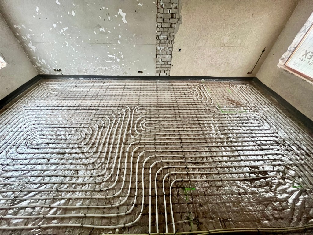 Vloerverwarming met slakkenhuis patroon op netten, als efficiënte oplossing voor primaire verwarming, geïnstalleerd door PIT Poppe Installatie Techniek.