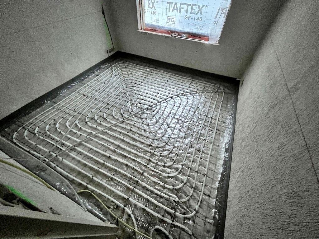 Nauwkeurig geplaatste vloerverwarming op netten in slakkenhuis patroon, geleverd en geïnstalleerd door PIT Poppe Installatie Techniek.